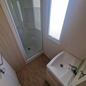 Baño con Lavabo y cabina de ducha con mampara