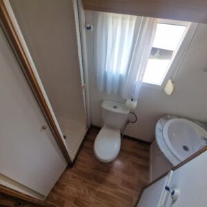 Baño con WC, lavabo y ducha con mampara